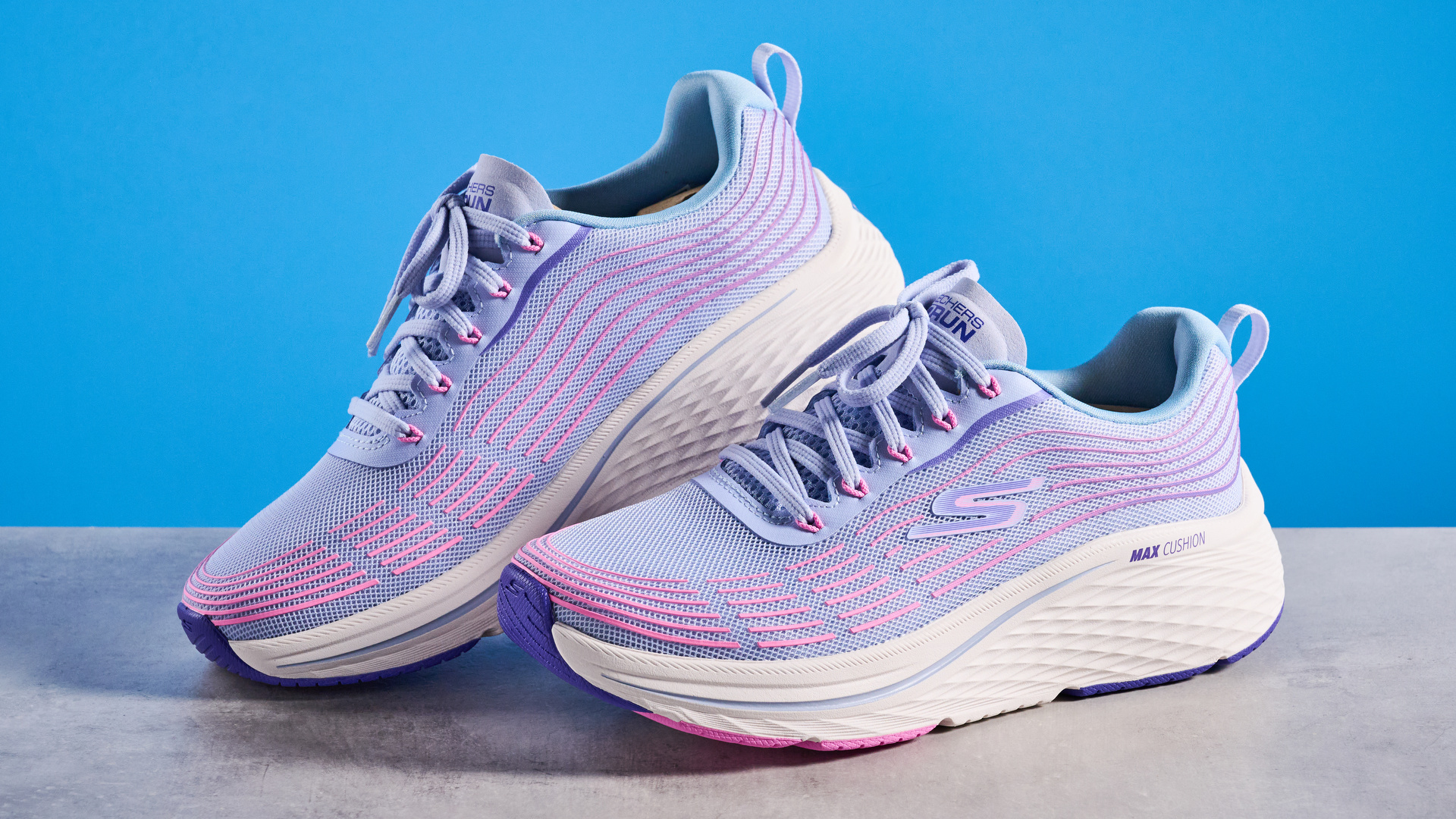Skechers Max Cushioning Elite 2.0 running shoes photographed in front of a blue background. 