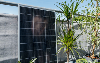 Solar panel on balcony next to plants