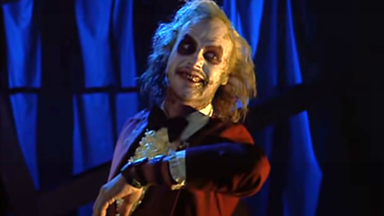 Michael Keaton as Beetlejuice wears a dark red tuxedo in his wedding scene with Lydia.