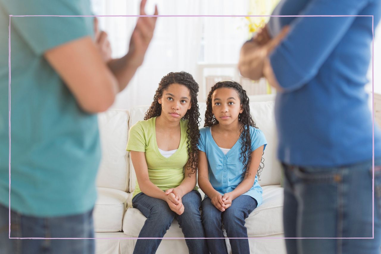 Co parenting couple talk while their daughters look on