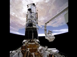 Astronaut F. Story Musgrave works to repair the Hubble Space Telescope on a spacewalk during the STS-61 mission.
