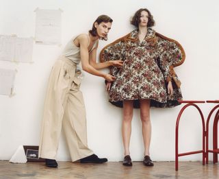 Man and woman pose together wearing dresses