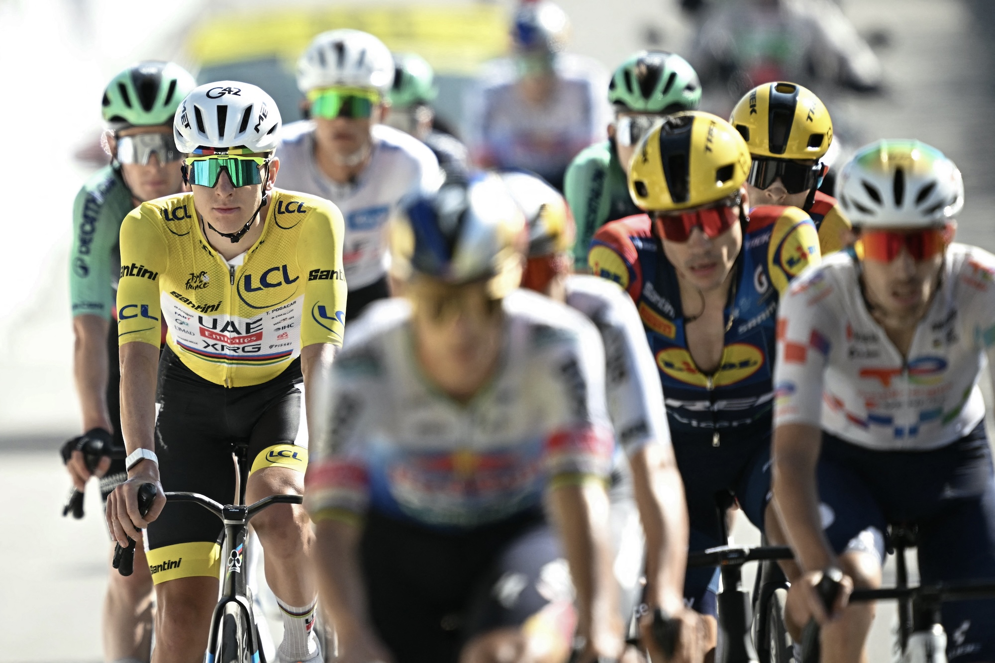 UAE Team Emirates - XRG's Slovenian rider Tadej Pogacar wearing the overall leader's yellow jersey cycles with the pack of riders (peloton) past the finish line of the 18th stage of the 113th edition of the Tour de France cycling race, 185,2 km between Voiron and Orci&egrave;res-Merlette in the French Alps, on July 23, 2026. (Photo by Loic VENANCE / AFP)