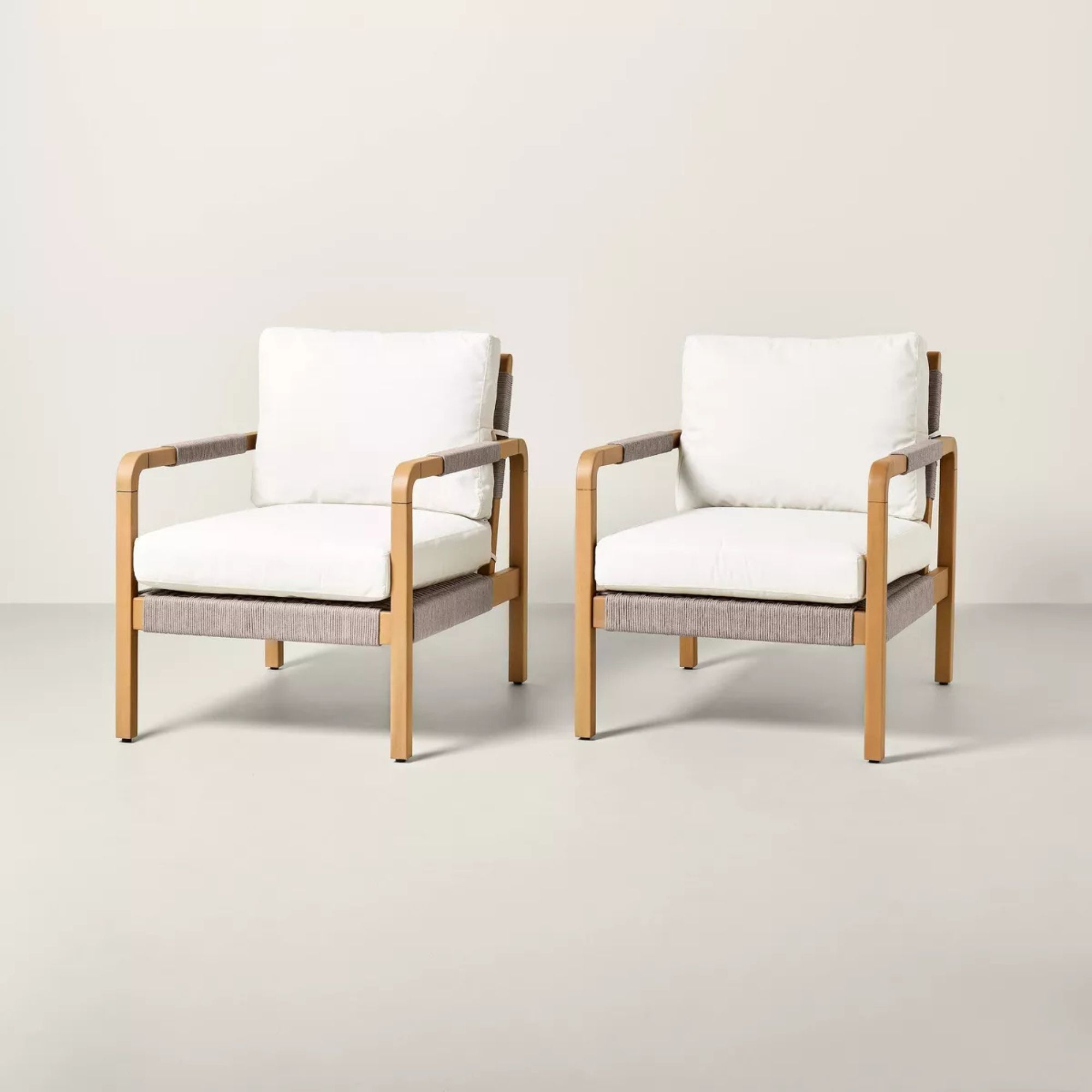 Rattan woven outdoor chairs with cream cushions