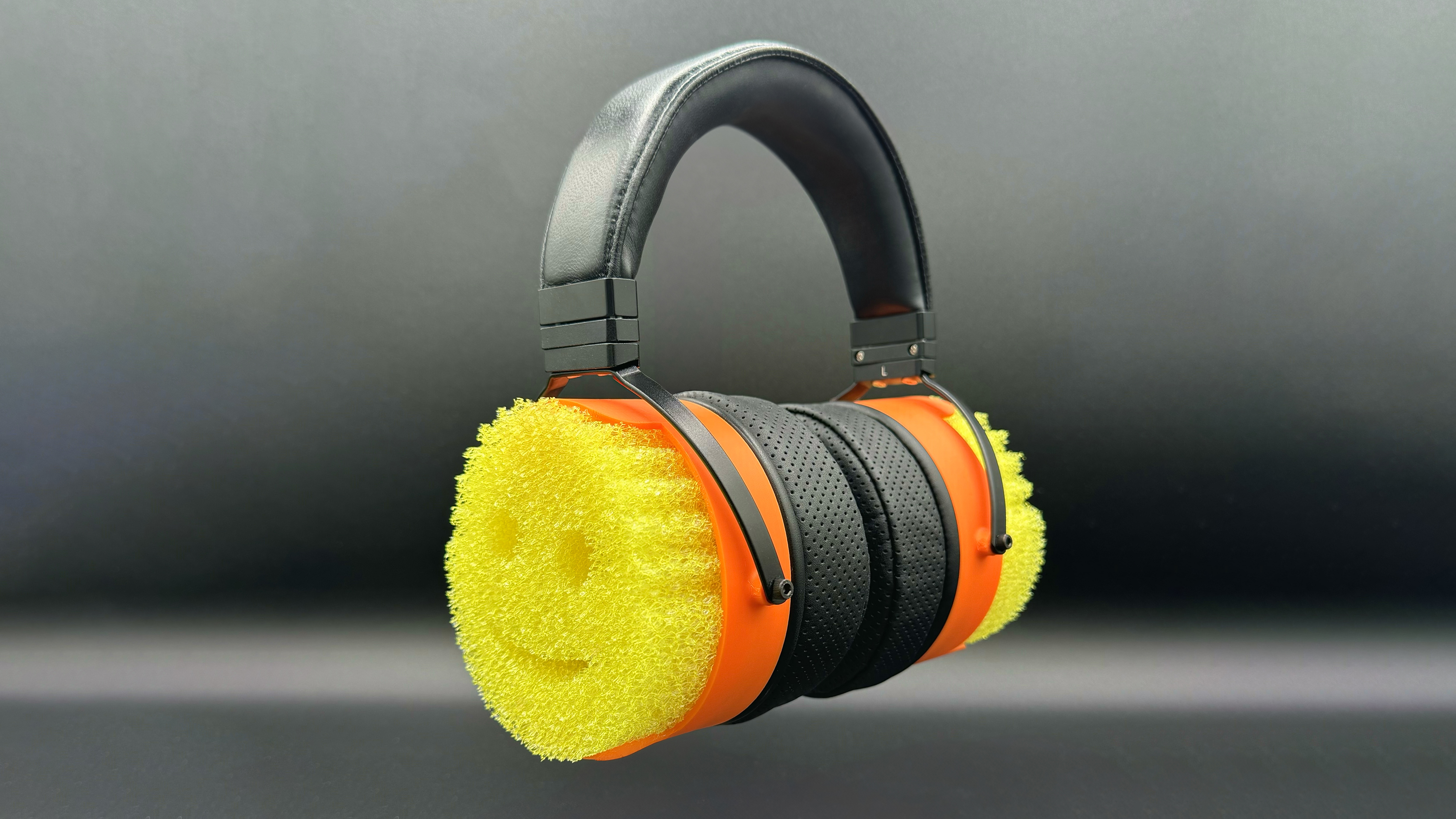 A pair of headphones with Scrub Daddy sponges on the outside of the earcups