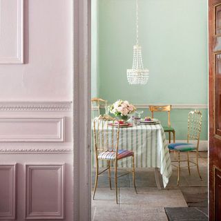 dining room with light blue wall and table with golden chairs