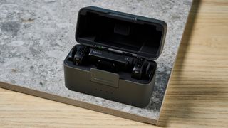 The DJI Mic Mini in black on a stone surface.