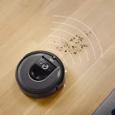 iRobot Roomba i7+ robot vacuum cleaner in promotional image being used on hard floors