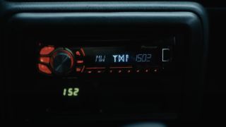 Mina's car radio malfunctioning and depicting runes in The Watchers