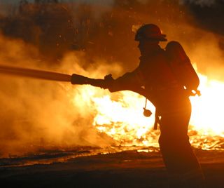 A firefighter battles a blaze. 