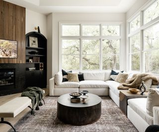 living room with white sectional and black alcove shelving and fireplace with wooden floors