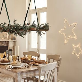 dining room dressed for Christmas with hanging foliage and star fairy lights