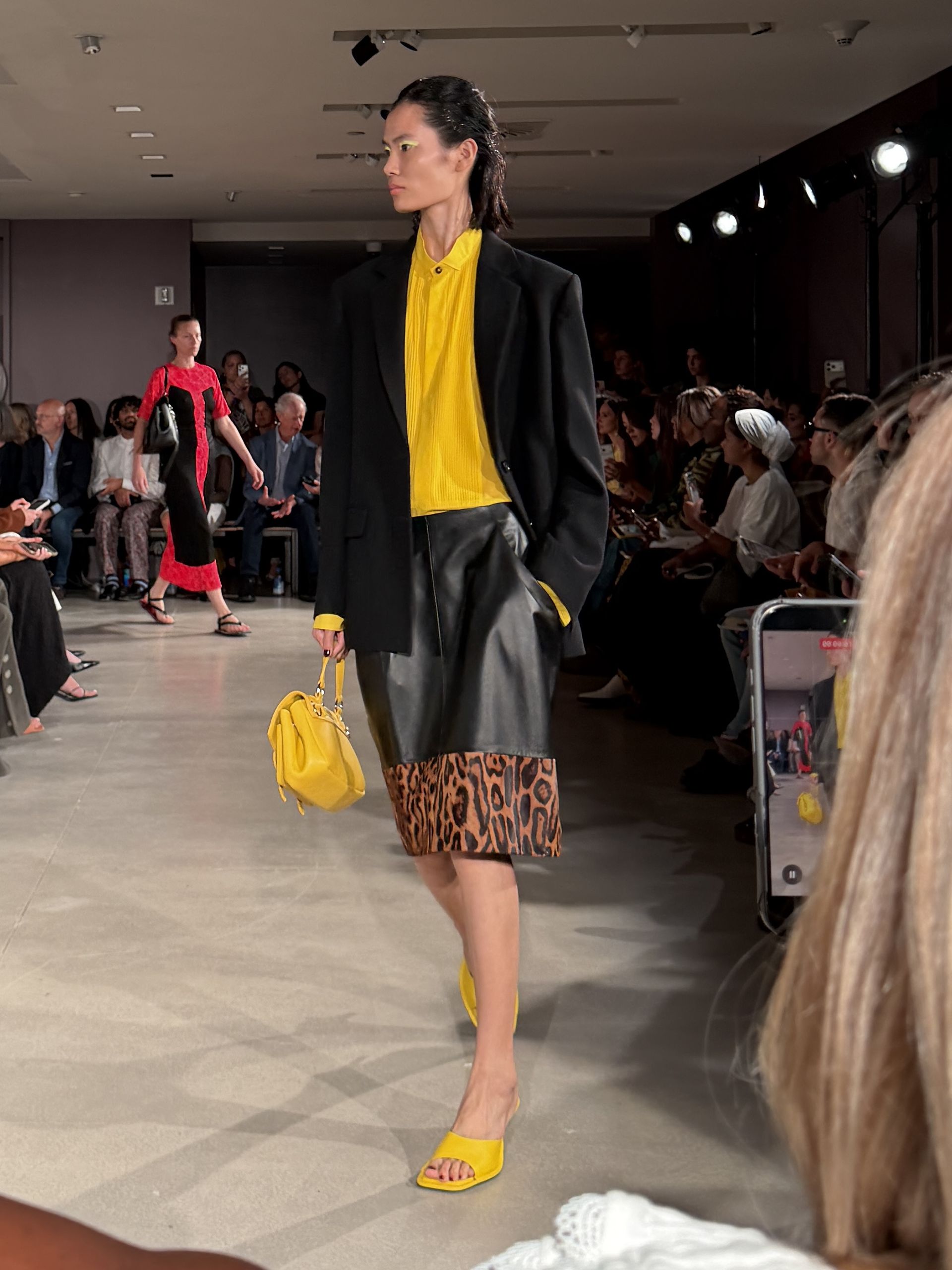 A model walking at the Proenza Schouler show during New York Fashion Week wearing a yellow top and a leopard-print skirt.