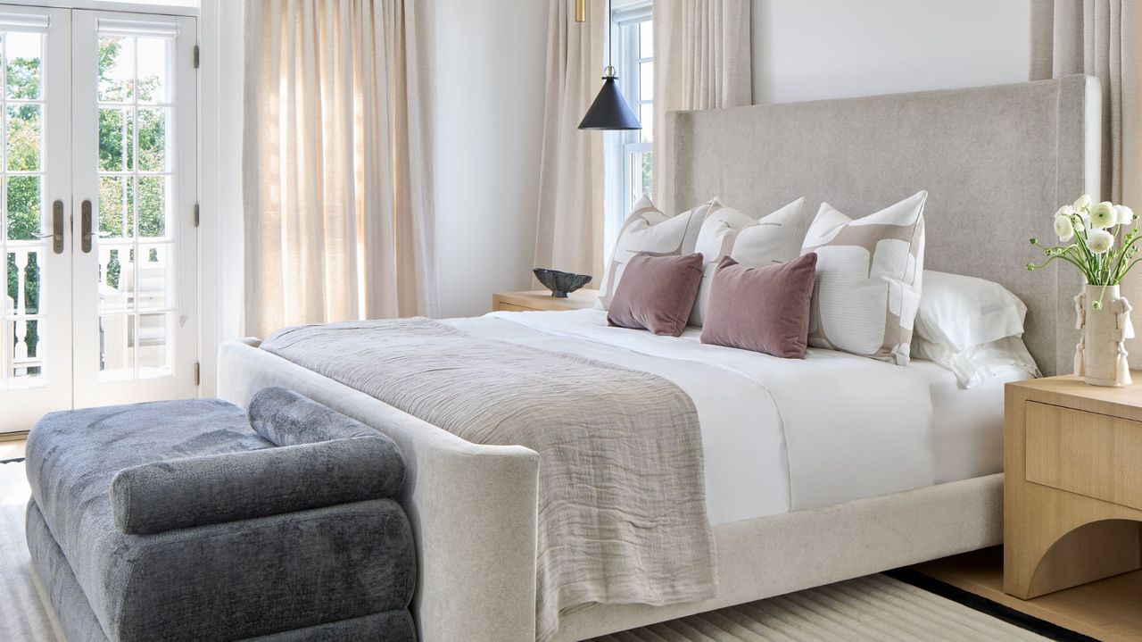 light colored bedroom with light grey velvet bed and oak bedside tables