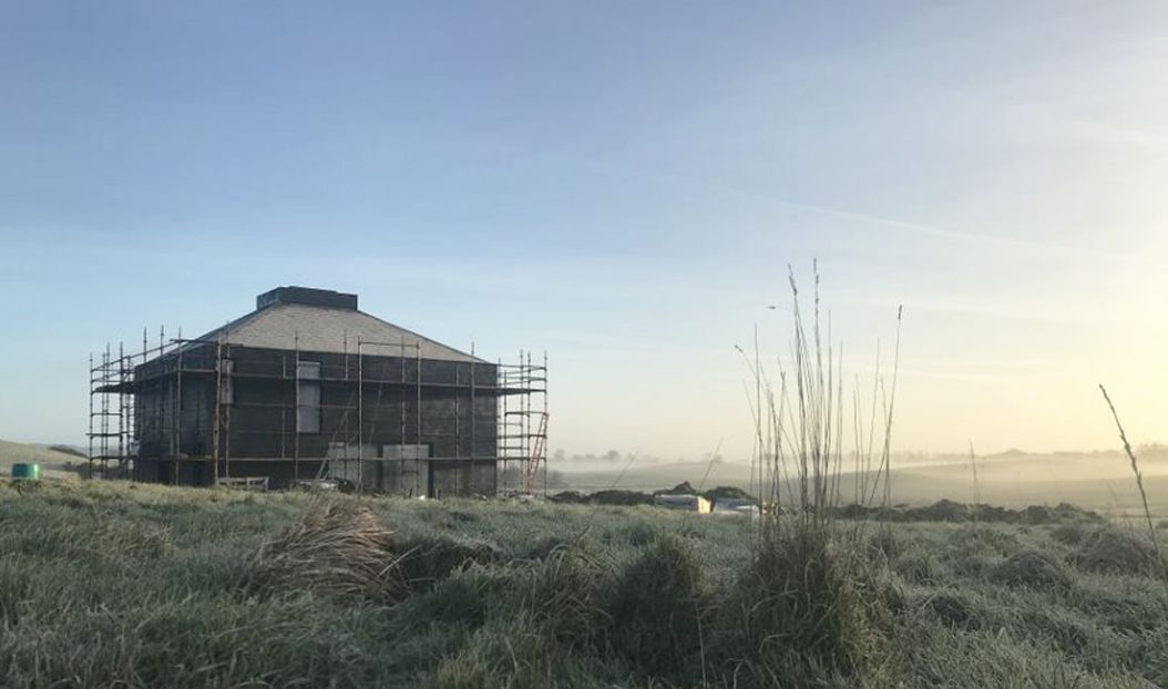 A house being constructed surrounded by scaffolding