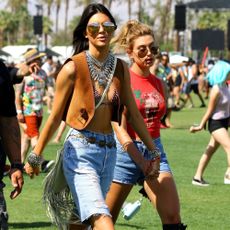 Kendall Jenner's 2015 Coachella outfit includes a suede vest and long denim shorts