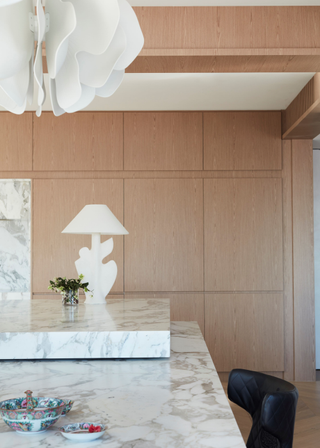 A kitchen with a wooden hosting closet and pantry