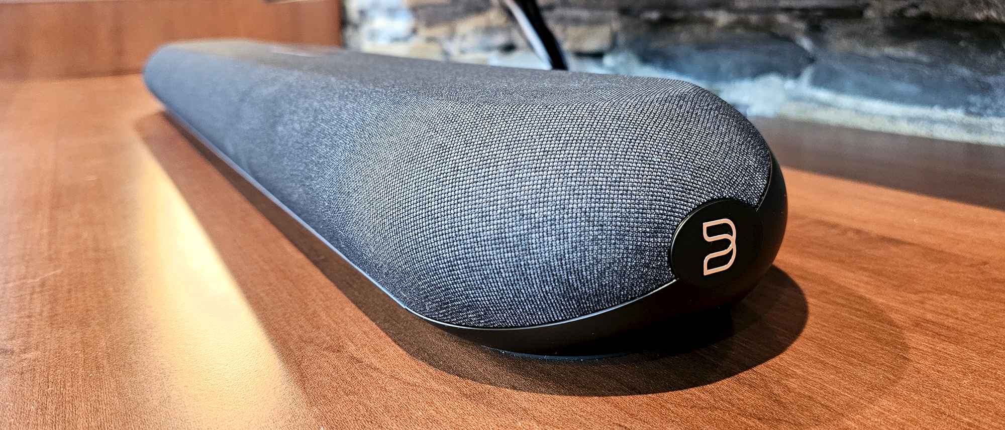 A close up of the Bluesound Pulse Mini soundbar on a wooden surface