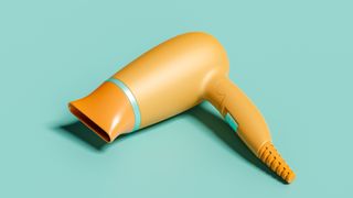 Image of cordless yellow hair dryer on a mint blue background