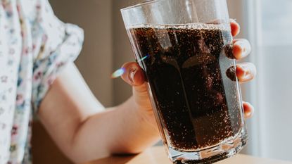 Child holding glass of soda