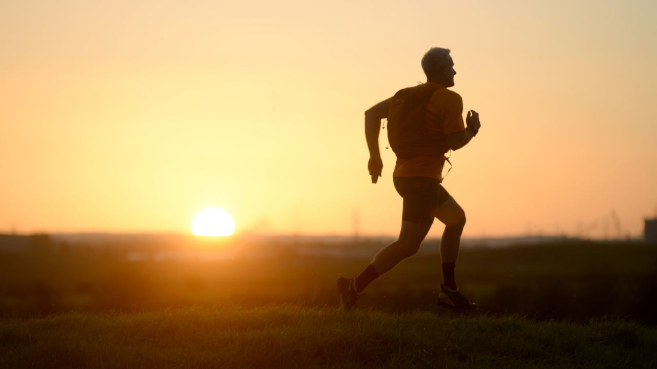 a man fastpacking in the sunset