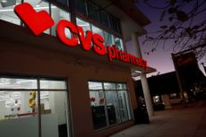 Outside of a CVS Pharmacy at night with store sign lit up in red