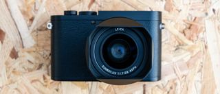 Et Leica Q2 Monochrom ligger på en træplade