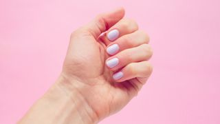 A hand with lilac nail polish