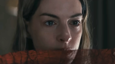 Anne Hathaway with red material by her mouth in Mother Mary 