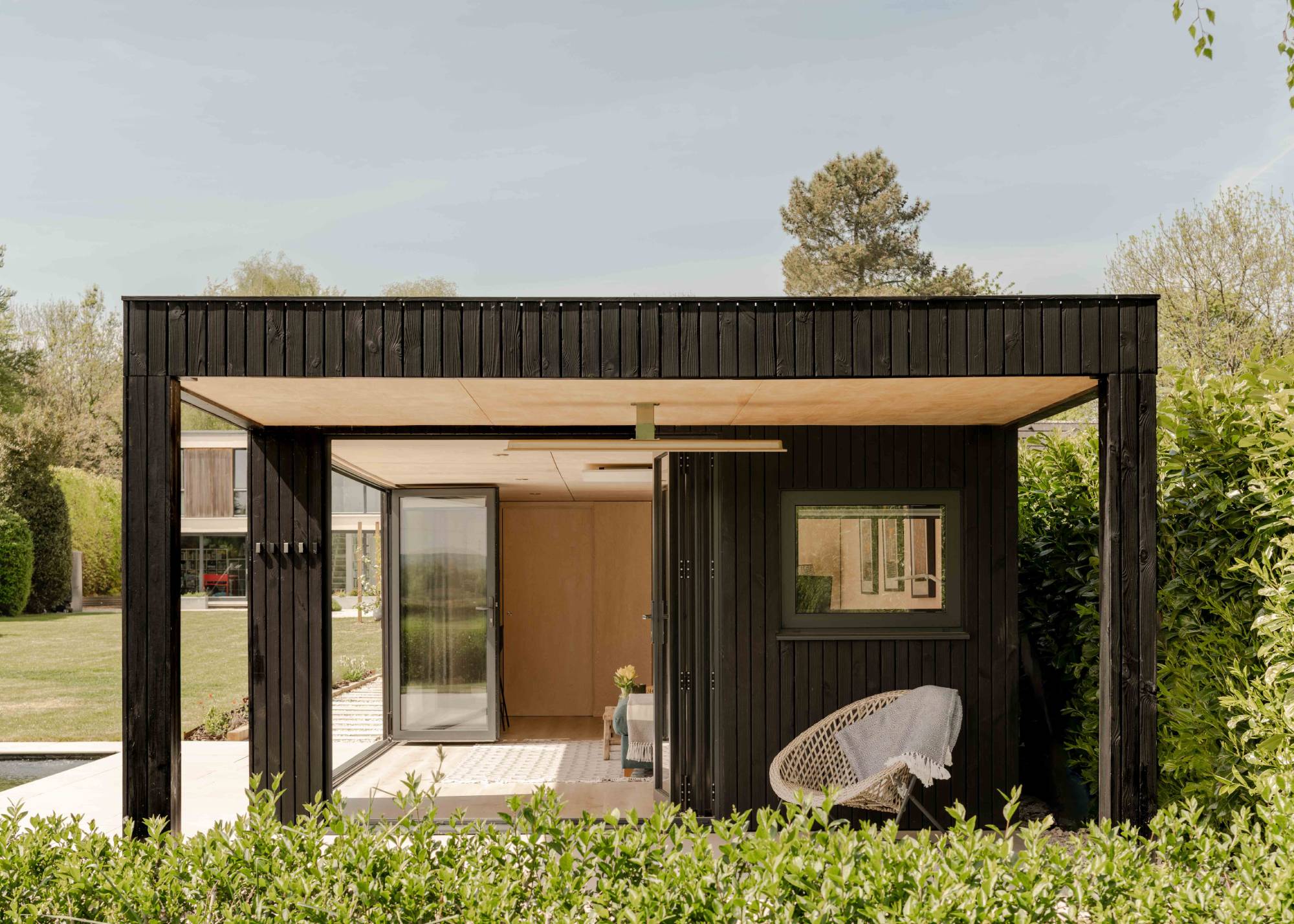 black timber clad garden room with veranda seating area