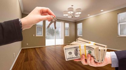 Agent Handing Over House Keys for Cash in Newly Remodeled Room of House.