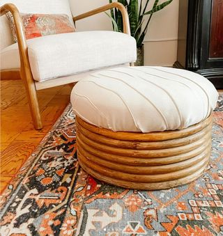 Finished footstool upholstered in cream fabric staged in living room