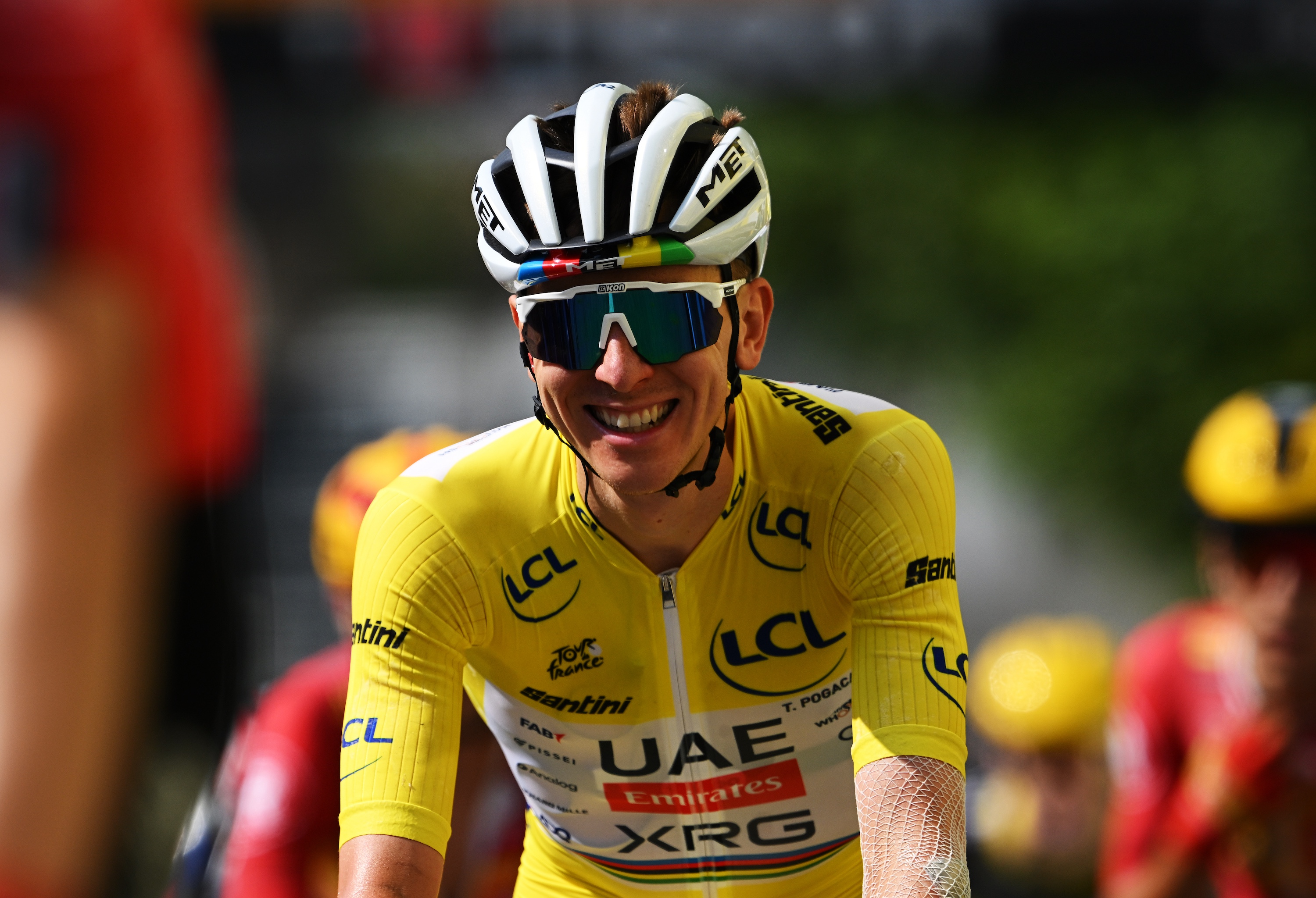 Tadej Pogačar smiles in the yellow jersey