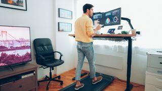 Man walking on one of the best under-desk treadmills at home