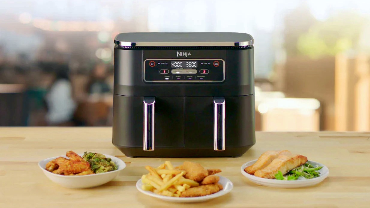 Three plates of food around the Ninja Foodi Dual Zone Air Fryer AF300