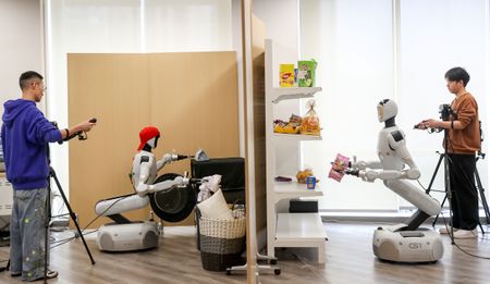 A technician trains a humanoid robot in commercial retail and home service scenarios at an embodied intelligence training center on April 8, 2026 in Yibin, Sichuan Province of China. 