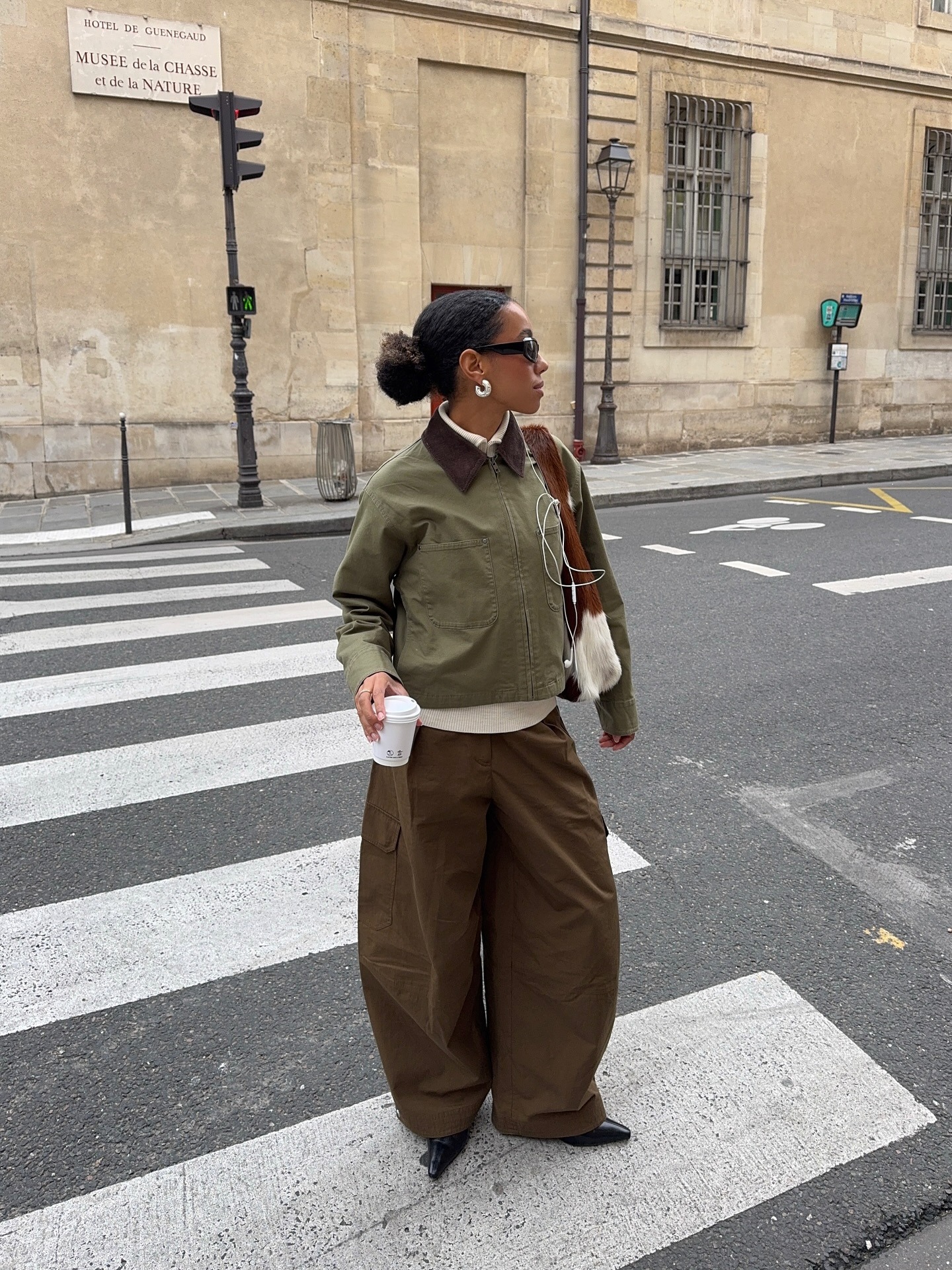 Influencer @amaka.hamelijnck wears a khaki jacket with voluminous khaki trousers and pointed-toe shoes.