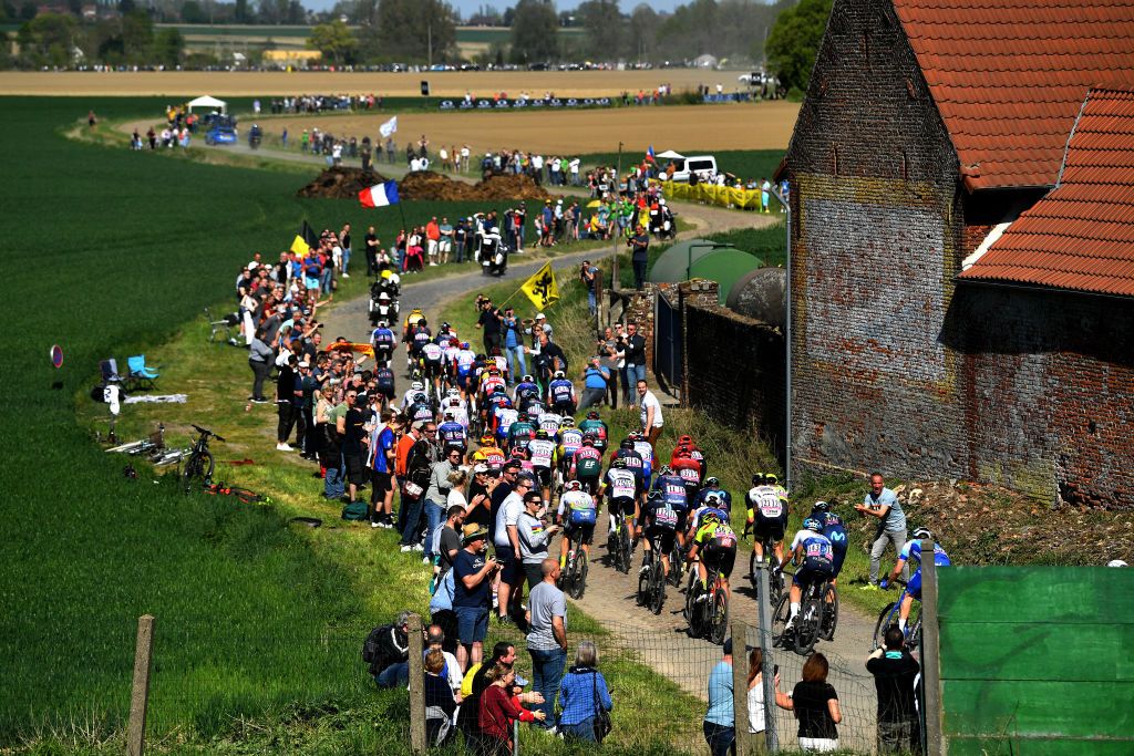 ROUBAIX FRANCE APRIL 17 A general view of the peloton compete passing through a Orchies cobblestones sector landscape during the 119th ParisRoubaix 2022 Mens Elite a 2572km one day race from Compigne to Roubaix ParisRoubaix WorldTour on April 17 2022 in Roubaix France Photo by Luc ClaessenGetty Images