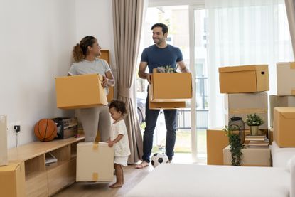Family holding moving boxes.