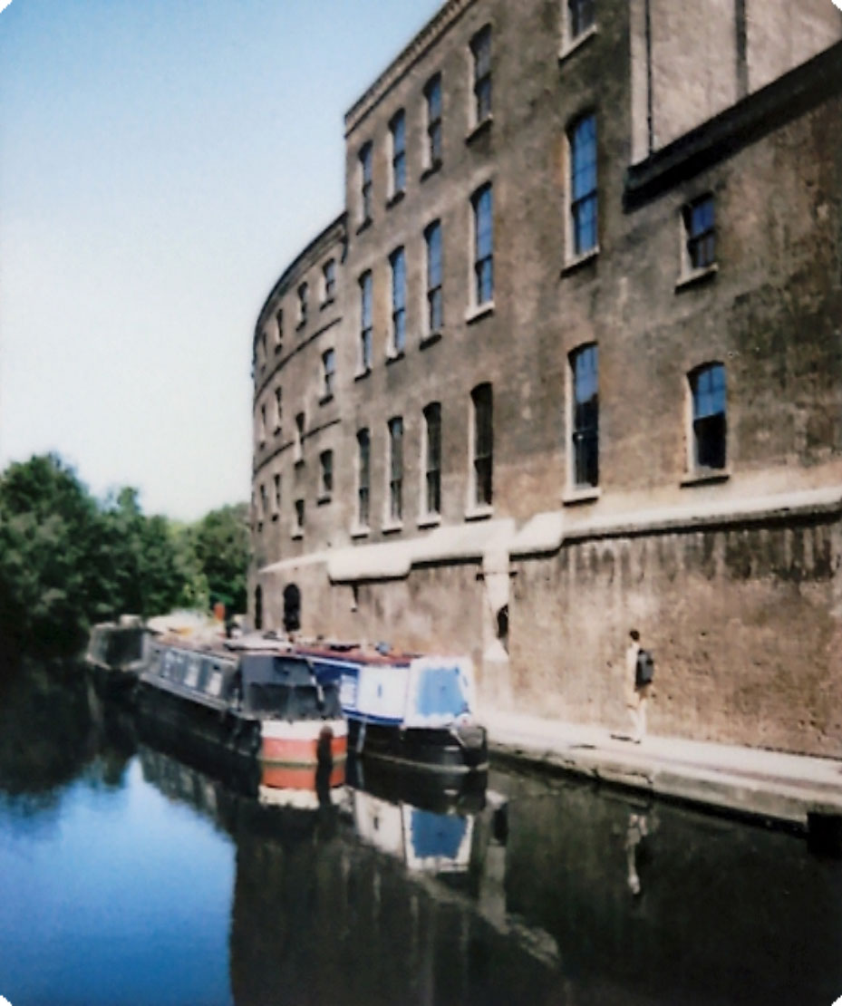 Digitized instant photo taken with the Fujifilm Instax SQ40 of old building along a canal on sunny day