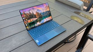 A Lenovo Yoga Slim 9i sitting on a picnic table outside