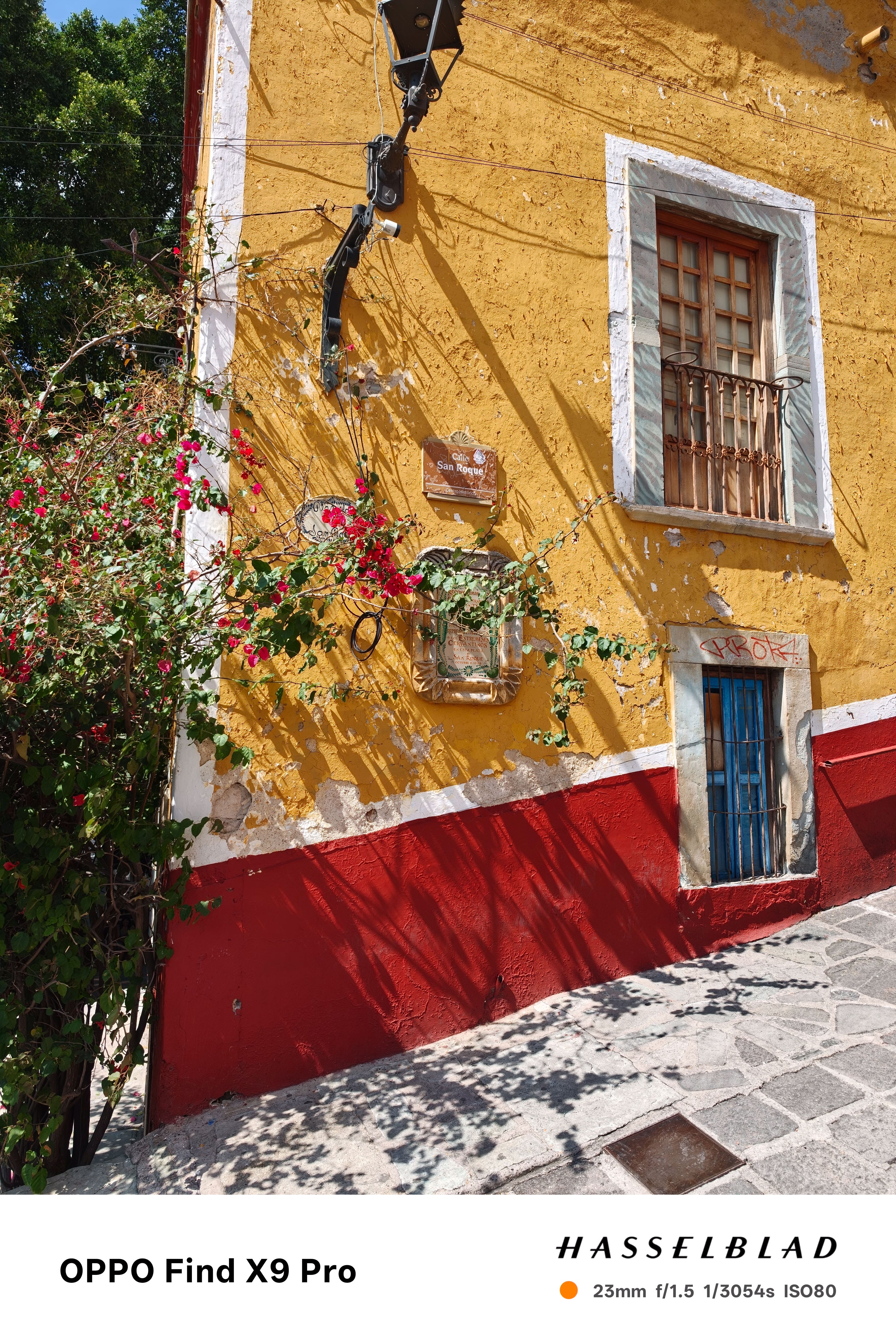 A street corner with a colourful yellow and red house
