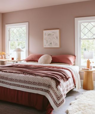 bedroom with light pink color scheme, dark pink and white bedding