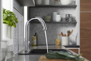 A simple silver faucet with running water