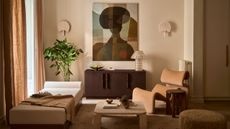 Living room with warm white walls, a mix of cream boucle and wood curved furniture, abstract figurative wall art, cream fan sconces and a neutral rug