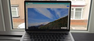 Wix website being edited on MacBook, in front of a window overlooking a terraced street