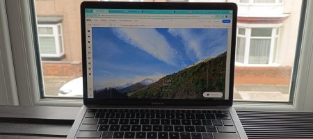 Wix website being edited on MacBook, in front of a window overlooking a terraced street