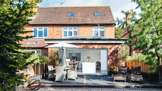 single storey rear extension on semi-detached brick house with patio and outdoor seating area