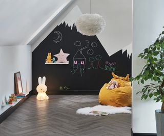 playroom with blackboard paint on wall and darker wooden floor