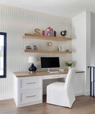 Neutral office space in hallway with floating shelves and white office chair